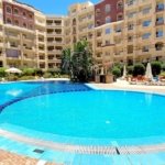 Studio apartment for sale in Florenza Khamsin Hurghada Luxury swimming pool at Florenza Khamsin surrounded by palm trees and elegant resort-style architecture.