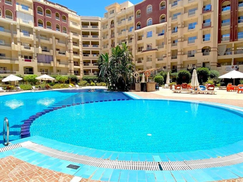 Florenza Khamsin – Luxury Pool Area Studio apartment for sale in Florenza Khamsin Hurghada Luxury swimming pool at Florenza Khamsin surrounded by palm trees and elegant resort-style architecture.