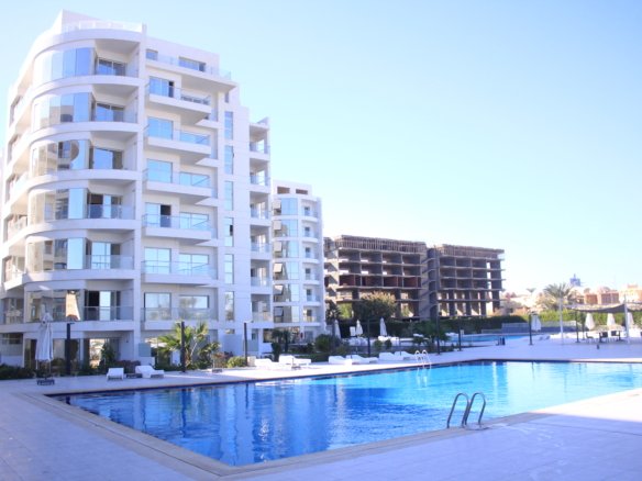 Residents enjoying the swimming pool surrounded by Scandinavian-style buildings at Scandic Hurghada.