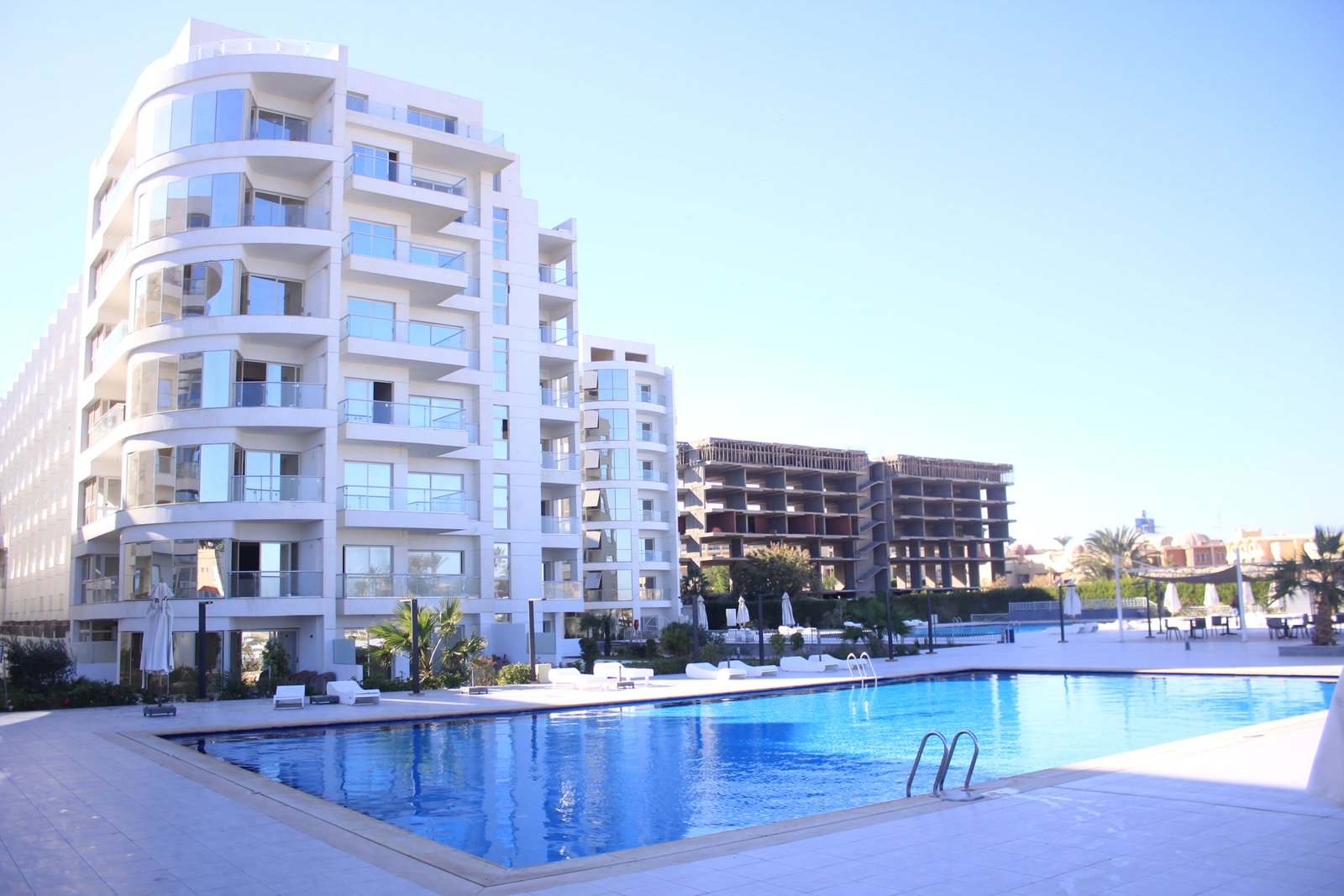 Residents enjoying the swimming pool surrounded by Scandinavian-style buildings at Scandic Hurghada.