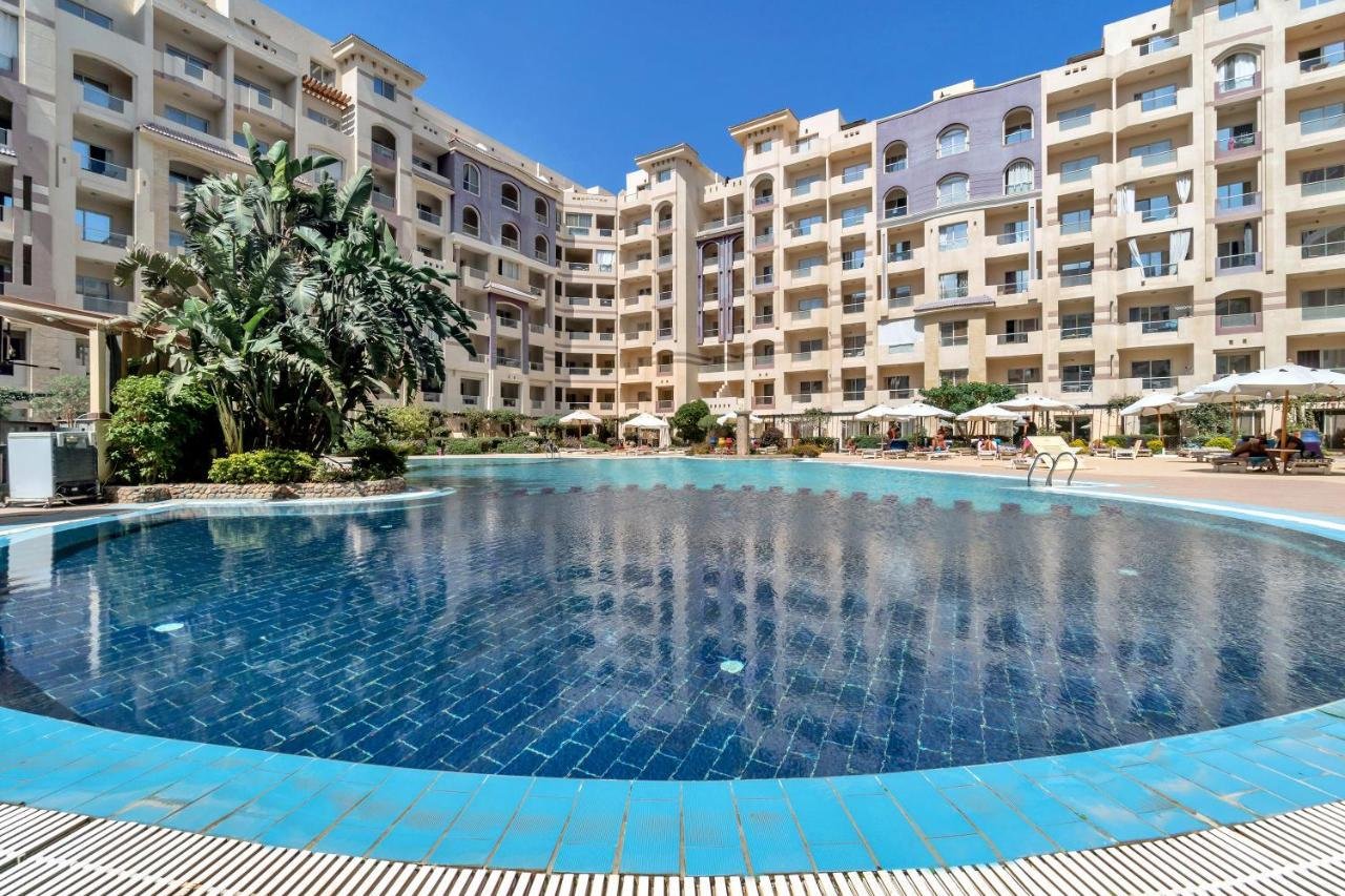 Florenza Khamsin – Luxury Pool Area Luxury swimming pool at Florenza Khamsin surrounded by palm trees and elegant resort-style architecture.