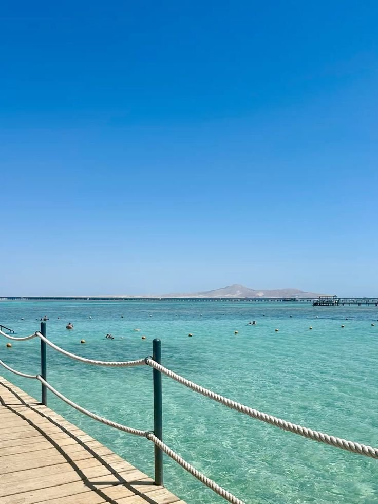 Residential clusters surrounding a crystal-clear swimmable lagoon with kitesurfers in the distance.