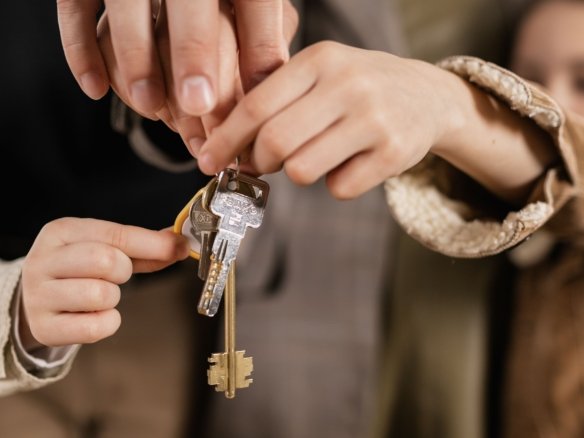 A first-time buyer signing property closing documents with a pen