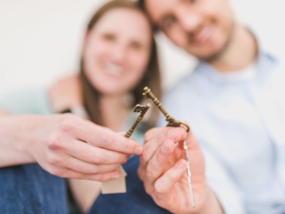 buying a house with a friend Two friends holding the keys to their new co-bought home