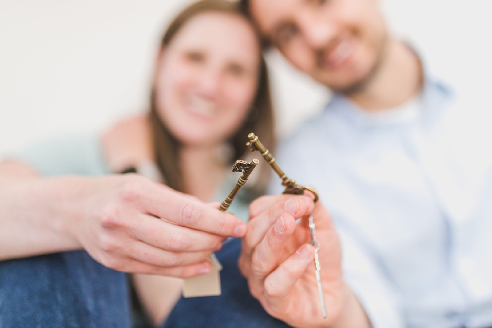 buying a house with a friend Two friends holding the keys to their new co-bought home
