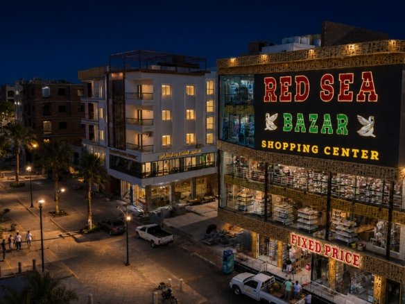 Street view mockup of Grand Rock Hurghada entrance located directly on the busy tourist strip of El Mamsha El Seyahi.
